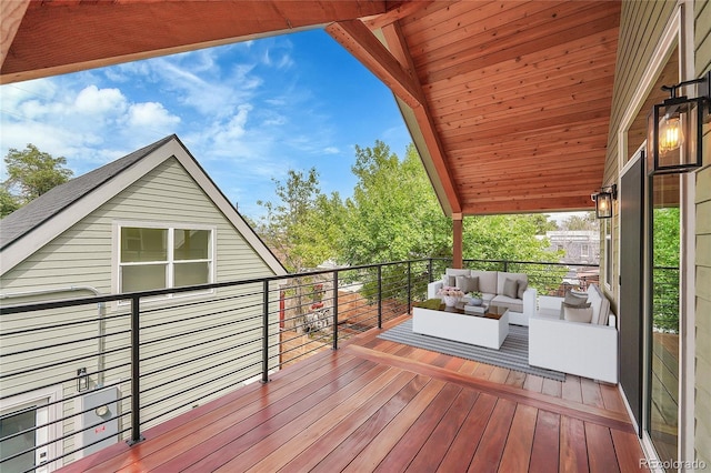 wooden terrace with an outdoor living space