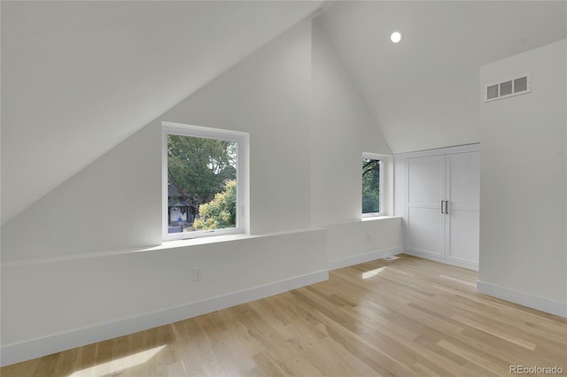 additional living space featuring lofted ceiling, recessed lighting, visible vents, baseboards, and light wood finished floors