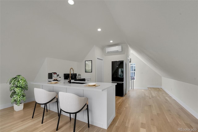 interior space featuring lofted ceiling, light wood-style flooring, recessed lighting, a sink, and a wall mounted AC