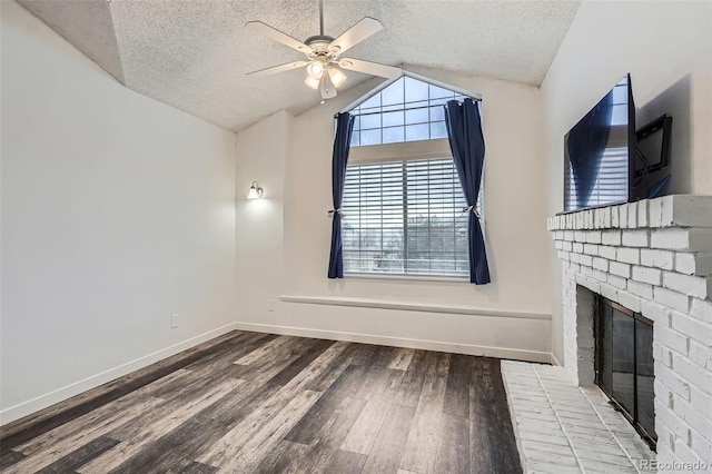 unfurnished living room featuring a fireplace, a textured ceiling, a ceiling fan, wood finished floors, and lofted ceiling