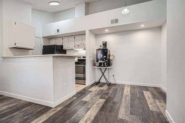 kitchen featuring white cabinets, stainless steel electric stove, black fridge, and visible vents