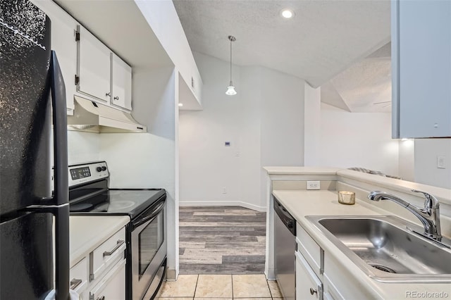 kitchen with appliances with stainless steel finishes, a sink, light countertops, white cabinetry, and under cabinet range hood