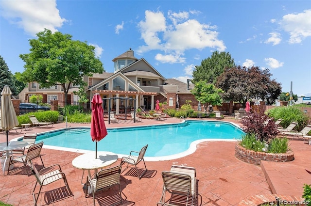 community pool with a patio and fence