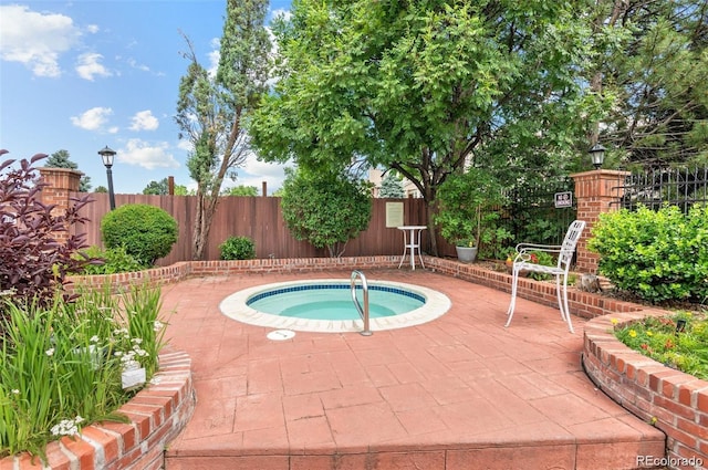 view of swimming pool featuring a patio, a fenced backyard, and a community hot tub