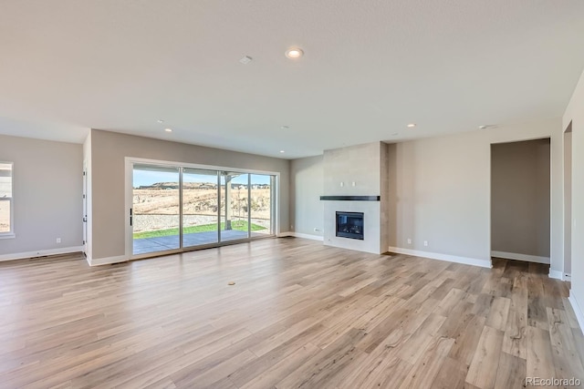 unfurnished living room with light hardwood / wood-style flooring and a large fireplace