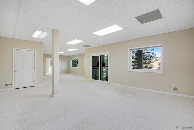 basement with a drop ceiling and light colored carpet