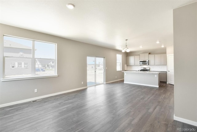 9910 Biscay St, Commerce City, CO 80022 - unfurnished living room with a chandelier, dark wood-style flooring, and recessed lighting