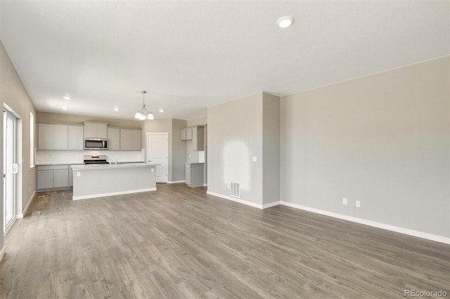 9910 Biscay St, Commerce City, CO 80022 - unfurnished living room with recessed lighting, a chandelier, and wood finished floors