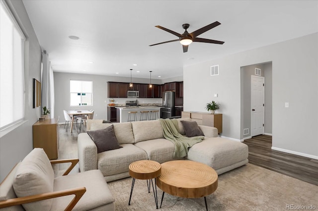 living room featuring ceiling fan and light hardwood / wood-style flooring