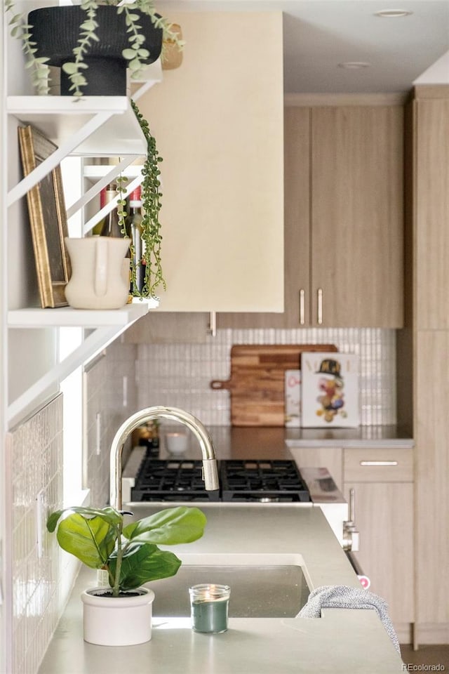 kitchen featuring decorative backsplash, light countertops, and light brown cabinetry