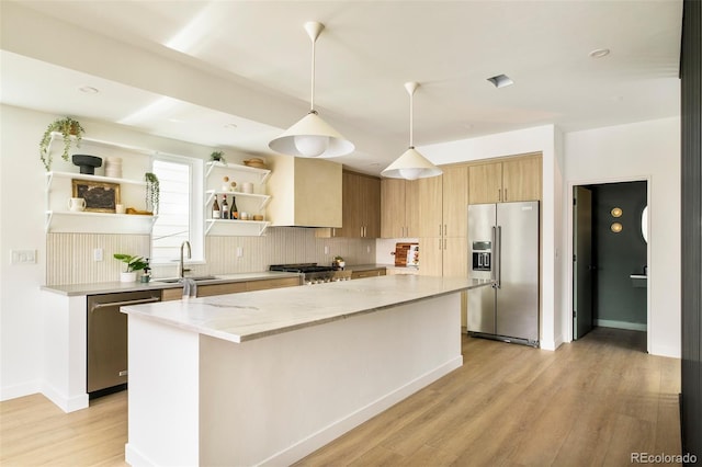kitchen featuring appliances with stainless steel finishes, open shelves, backsplash, a kitchen island, and a sink