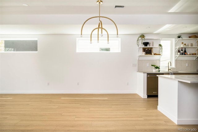 unfurnished dining area with light wood-style floors, plenty of natural light, a sink, baseboards, and recessed lighting