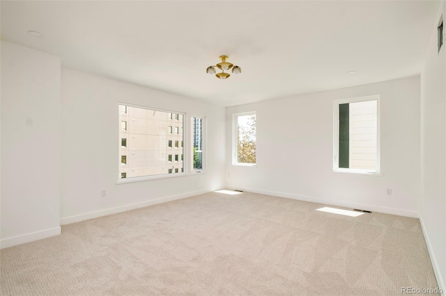 carpeted empty room featuring baseboards