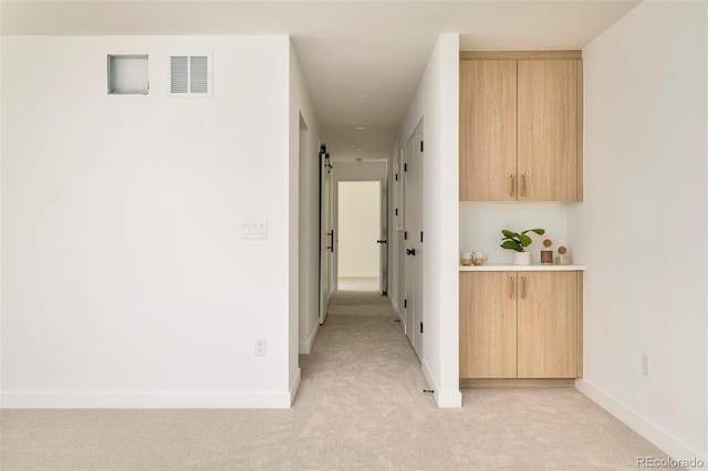 hallway with light colored carpet and baseboards