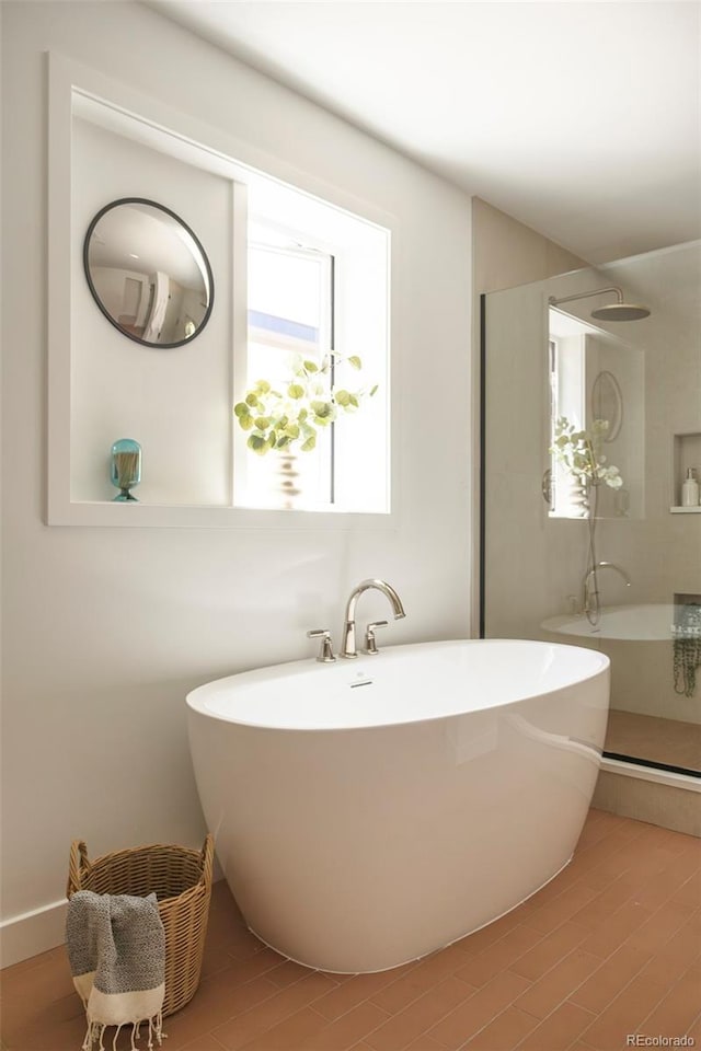 bathroom featuring wood finished floors, walk in shower, and a freestanding bath