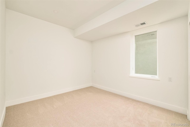 spare room with light colored carpet and baseboards