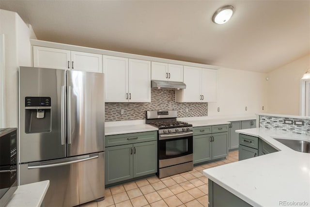 kitchen featuring stainless steel appliances, tasteful backsplash, green cabinetry, under cabinet range hood, and light countertops
