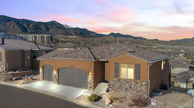 view of front of property with a mountain view and a garage