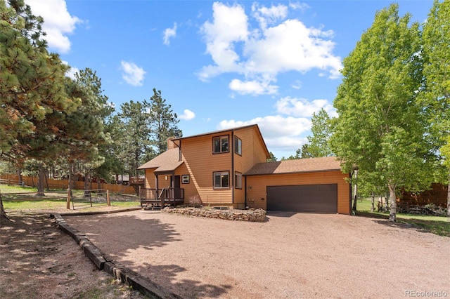 1345 Leslie Cir, Woodland Park, CO 80863 - view of front of property featuring an attached garage, driveway, a wooden deck, and roof with shingles