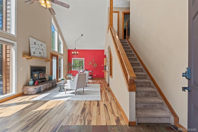1345 Leslie Cir, Woodland Park, CO 80863 - living area featuring a towering ceiling, a wood stove, stairs, and ceiling fan