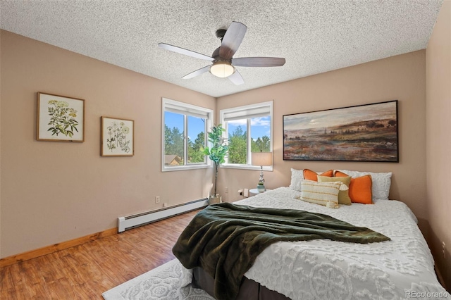 1345 Leslie Cir, Woodland Park, CO 80863 - bedroom featuring a baseboard heating unit, wood finished floors, a textured ceiling, and a ceiling fan