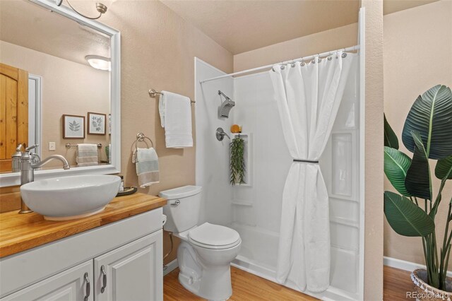 1345 Leslie Cir, Woodland Park, CO 80863 - full bathroom with vanity, wood finished floors, and a shower with curtain
