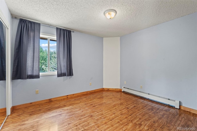 1345 Leslie Cir, Woodland Park, CO 80863 - spare room featuring baseboard heating, wood finished floors, and a textured ceiling