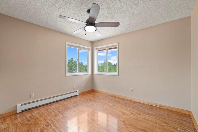 1345 Leslie Cir, Woodland Park, CO 80863 - unfurnished room with a baseboard radiator, ceiling fan, wood finished floors, and a textured ceiling