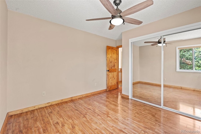 1345 Leslie Cir, Woodland Park, CO 80863 - unfurnished bedroom featuring wood finished floors, a closet, a textured ceiling, and ceiling fan