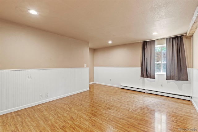 1345 Leslie Cir, Woodland Park, CO 80863 - empty room featuring baseboard heating, wood finished floors, wainscoting, and recessed lighting