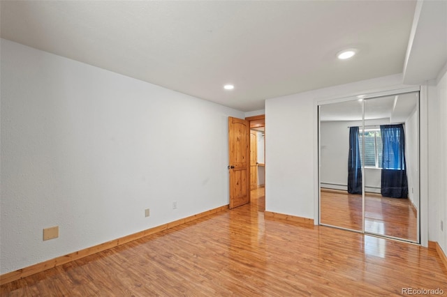 1345 Leslie Cir, Woodland Park, CO 80863 - unfurnished bedroom with light wood-type flooring, a baseboard radiator, a closet, and recessed lighting