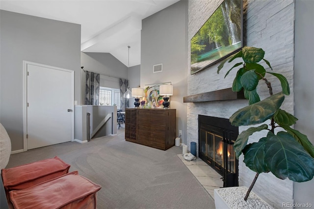 bedroom with a stone fireplace, light carpet, and high vaulted ceiling