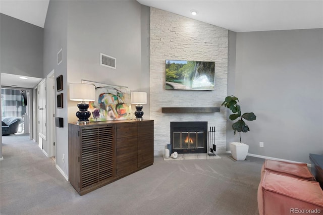 carpeted living room featuring a fireplace and high vaulted ceiling