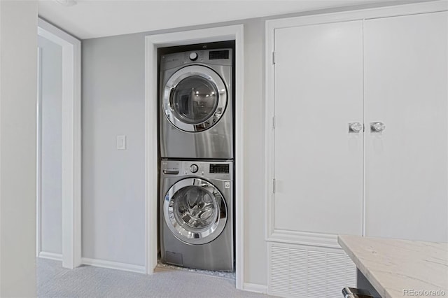 washroom with light carpet and stacked washing maching and dryer