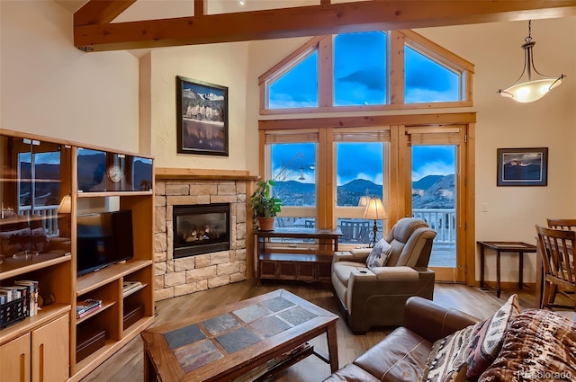 living room with a healthy amount of sunlight, vaulted ceiling with beams, and wood finished floors