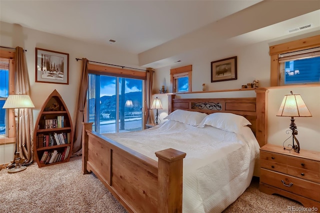 bedroom with light colored carpet, access to outside, and visible vents