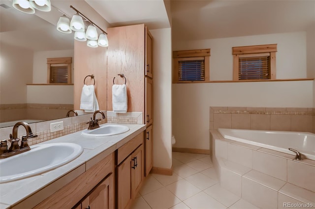 full bath featuring a sink, a garden tub, and tile patterned floors