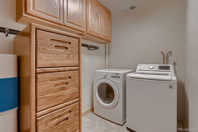 clothes washing area featuring cabinet space, washing machine and dryer, and visible vents