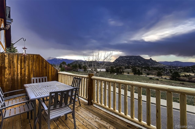 wooden deck featuring outdoor dining space and a mountain view