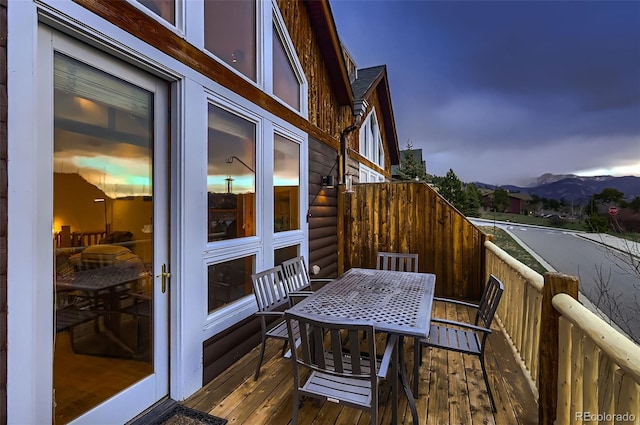 balcony featuring outdoor dining area and a deck with mountain view