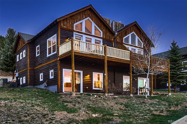 back of property with faux log siding and a wooden deck