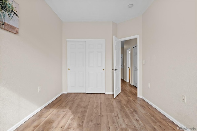 unfurnished bedroom with light hardwood / wood-style floors and a closet