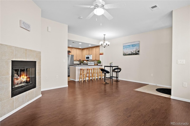 living room featuring dark hardwood / wood-style flooring, sink, an inviting chandelier, and a fireplace