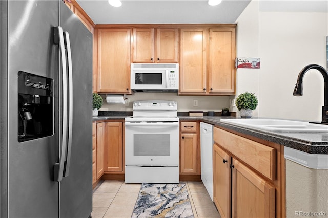 kitchen featuring sink, light tile patterned floors, and white appliances