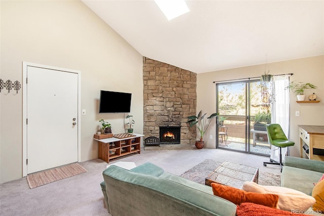 carpeted living room featuring high vaulted ceiling, a skylight, and a fireplace