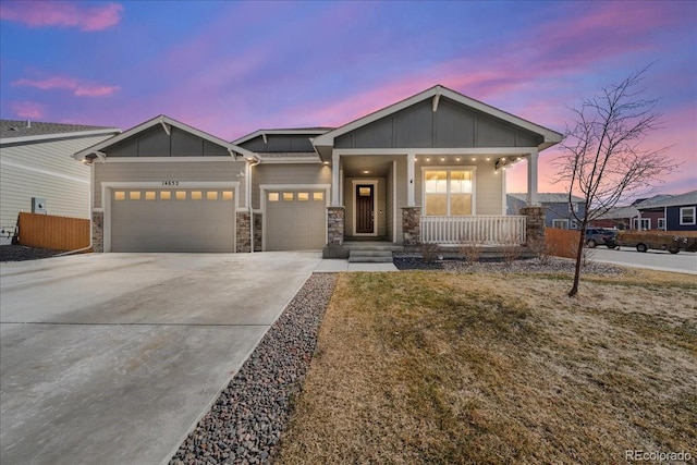 view of front of property with covered porch, board and batten siding, fence, a garage, and driveway