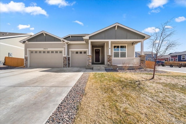 view of front of property featuring covered porch, concrete driveway, board and batten siding, fence, and a garage