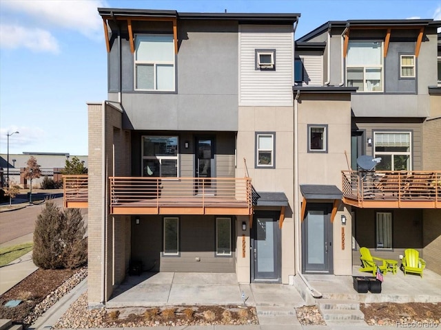 rear view of property featuring a patio and stucco siding