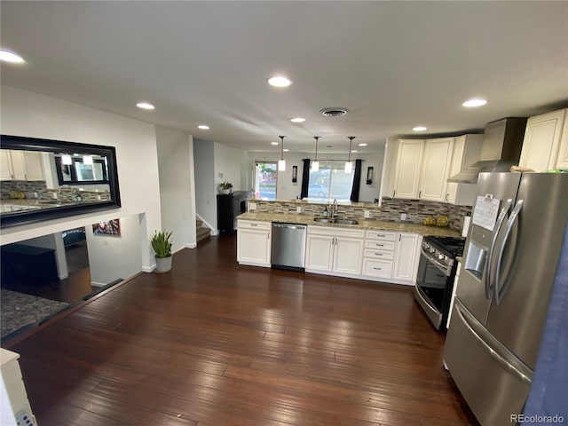 7132 Xavier Way, Westminster, CO 80030 - kitchen with appliances with stainless steel finishes, a sink, a peninsula, backsplash, and white cabinetry