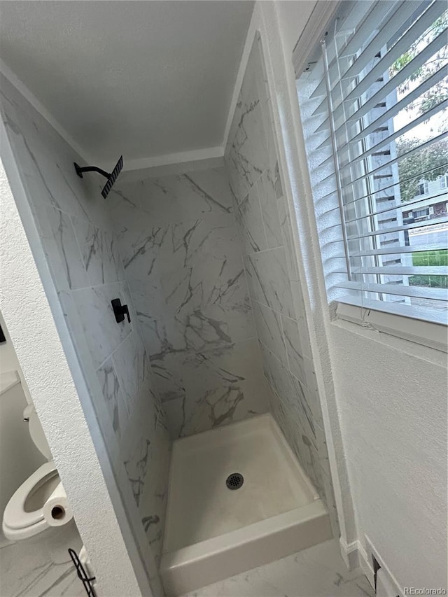 7132 Xavier Way, Westminster, CO 80030 - bathroom with marble look tiles, a shower stall, and toilet